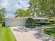 Single-story home featuring a pristine front lawn, driveway and mature landscaping at 1541 Flower Dr, Sarasota, FL 34239