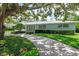 Charming single-story home featuring a well-manicured lawn and lush green shrubbery at 1541 Flower Dr, Sarasota, FL 34239