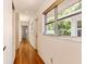Hallway featuring hardwood floors, natural light from large windows, and storage closets at 1541 Flower Dr, Sarasota, FL 34239