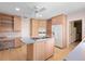 This kitchen has a cooktop island, light wood cabinets, and modern appliances at 1541 Flower Dr, Sarasota, FL 34239