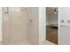 Walk-in shower with neutral tiling and a showerhead; bathroom includes a bedroom and towel rack at 1541 Flower Dr, Sarasota, FL 34239