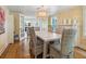 Bright dining room with wood floors, a farmhouse table, and seating for six underneath a rattan chandelier at 1732 6Th St, Sarasota, FL 34236