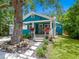 Charming blue bungalow featuring a covered porch, stone pathway, and lush landscaping at 1732 6Th St, Sarasota, FL 34236