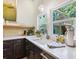 Modern kitchen features dark wood cabinets, white countertops, and a farmhouse sink beneath a window overlooking the backyard at 1732 6Th St, Sarasota, FL 34236