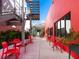 Vibrant outdoor seating area with red chairs and tables near modern building with industrial stairs at 1732 6Th St, Sarasota, FL 34236
