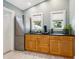 Wet bar features light wood cabinets, a refrigerator, a sink, and two windows at 1732 6Th St, Sarasota, FL 34236