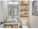 Charming bathroom with wood accents, floating shelves, and a unique vanity with storage baskets below at 17320 Polo Trl, Bradenton, FL 34211