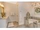 Relaxing bathroom featuring soaking tub with grey tiling, chandelier, and vanity with marble countertop at 17320 Polo Trl, Bradenton, FL 34211