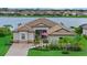Beautiful single-Gathering home with a gorgeous yard, landscaping, and a glimpse of the serene lake in the background at 17320 Polo Trl, Bradenton, FL 34211