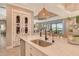 Bright, open kitchen with stainless steel appliances, large island, and stylish pendant lighting, perfect for entertaining at 17320 Polo Trl, Bradenton, FL 34211