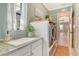 Laundry room featuring a granite countertop sink, front loading washer and dryer, and natural light at 17320 Polo Trl, Bradenton, FL 34211