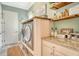 Convenient laundry room with built-in washer and dryer, granite countertop and wooden shelving at 17320 Polo Trl, Bradenton, FL 34211