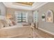 Bright main bedroom with tray ceiling, plush bedding, and windows with sheer curtains at 17320 Polo Trl, Bradenton, FL 34211