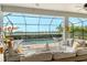 Comfortable screened patio seating area overlooking a sparkling pool, relaxing spa, and serene lake view at 17320 Polo Trl, Bradenton, FL 34211
