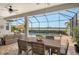 Spacious screened patio with dining and seating area overlooking a pool and scenic waterfront view at 17320 Polo Trl, Bradenton, FL 34211