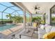 Expansive screened-in patio with cozy seating and dining areas, overlooking the pool, spa, and lake at 17320 Polo Trl, Bradenton, FL 34211