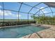 Sparkling pool and spa area surrounded by a screened enclosure and lush landscaping with a lake view at 17320 Polo Trl, Bradenton, FL 34211