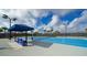 Bright blue tennis court features shaded seating and well-maintained surroundings on a sunny day at 17320 Polo Trl, Bradenton, FL 34211