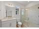 Clean bathroom with a single sink vanity, toilet, and tiled shower with glass door at 17823 Cherished Loop, Bradenton, FL 34211