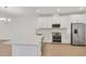 Modern kitchen with stainless steel appliances, white cabinets, and a quartz countertop island at 17823 Cherished Loop, Bradenton, FL 34211