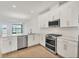 Well-lit kitchen with white cabinets, stainless steel appliances, and a water view from the breakfast bar at 17823 Cherished Loop, Bradenton, FL 34211