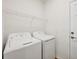 Functional laundry room featuring washer, dryer, wire shelving, and white walls at 17823 Cherished Loop, Bradenton, FL 34211