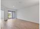 Large, empty room with light wood floors, sliding glass doors and an open layout at 17823 Cherished Loop, Bradenton, FL 34211