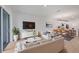 Bright, modern living room featuring a large tv, white furniture and an open floor plan at 17823 Cherished Loop, Bradenton, FL 34211