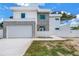 Contemporary home featuring a clean white facade, gray accents, and a wide driveway at 2065 Goldenrod St, Sarasota, FL 34239