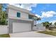 Modern two-story home featuring a clean white facade, gray accents, and a wide driveway at 2065 Goldenrod St, Sarasota, FL 34239