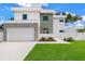 Modern two-story home featuring a clean white facade, gray accents, and a well-manicured lawn at 2065 Goldenrod St, Sarasota, FL 34239