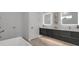 Bright bathroom showcasing a floating vanity with double sinks and decorative, lighted mirrors at 2124 Clematis Pl, Sarasota, FL 34239