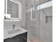 Modern bathroom with a gray vanity, LED mirror, and a glass-enclosed shower with marble tile at 2124 Clematis Pl, Sarasota, FL 34239