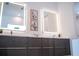 Modern bathroom showcasing double sinks with illuminated mirrors and sleek gray cabinetry at 2124 Clematis Pl, Sarasota, FL 34239