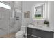 Well-lit bathroom featuring a glass-enclosed, marble-tiled shower, sleek vanity, and modern fixtures at 2124 Clematis Pl, Sarasota, FL 34239