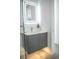 Modern bathroom vanity with gray cabinets, a sleek countertop, and a lighted mirror at 2124 Clematis Pl, Sarasota, FL 34239