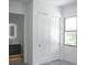 Bright bathroom featuring a sliding-door closet, floating vanity with lighted mirror, and window at 2124 Clematis Pl, Sarasota, FL 34239