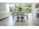 Dining area with a modern table set, large windows and sliding doors with views of lush greenery at 2124 Clematis Pl, Sarasota, FL 34239