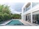 Back of modern two-story home featuring a swimming pool and lots of tropical landscaping at 2124 Clematis Pl, Sarasota, FL 34239