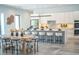 Bright open-concept kitchen with white cabinets, marble countertops, a large island, and stylish dining area at 2124 Clematis Pl, Sarasota, FL 34239