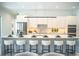 Modern kitchen with a large island, marble countertops, white cabinetry, and bar stool seating at 2124 Clematis Pl, Sarasota, FL 34239