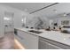Modern kitchen featuring a center island with bar seating, an open staircase, and integrated appliances at 2124 Clematis Pl, Sarasota, FL 34239