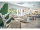 Bright living room showcasing neutral-toned furnishings, open to a kitchen with counter seating and modern decor at 2124 Clematis Pl, Sarasota, FL 34239