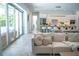 Bright living area with modern sectional sofa, sliding glass doors, and open view of kitchen and dining area at 2124 Clematis Pl, Sarasota, FL 34239