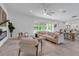 Spacious living room with a modern fireplace, open floorplan, and a neutral color palette with views of the yard at 2124 Clematis Pl, Sarasota, FL 34239