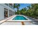 Backyard pool surrounded by a concrete deck, lush tropical foliage, and a modern two-story home at 2124 Clematis Pl, Sarasota, FL 34239