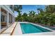 A refreshing backyard pool surrounded by lush tropical greenery and a modern patio at 2124 Clematis Pl, Sarasota, FL 34239