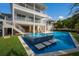 Image showcasing a three-story home overlooking the pool, hot tub, and manicured lawn at 227 S Harbor Dr, Holmes Beach, FL 34217