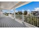 White balcony overlooking lush tropical foliage and other luxury homes in the community at 227 S Harbor Dr, Holmes Beach, FL 34217