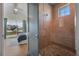 Elegant bathroom showing a stone shower and the bedroom view to the balcony at 227 S Harbor Dr, Holmes Beach, FL 34217